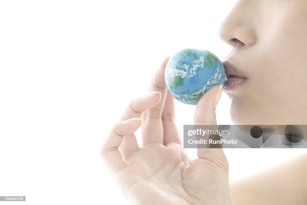 Young woman kissing the globe ball,lip close up