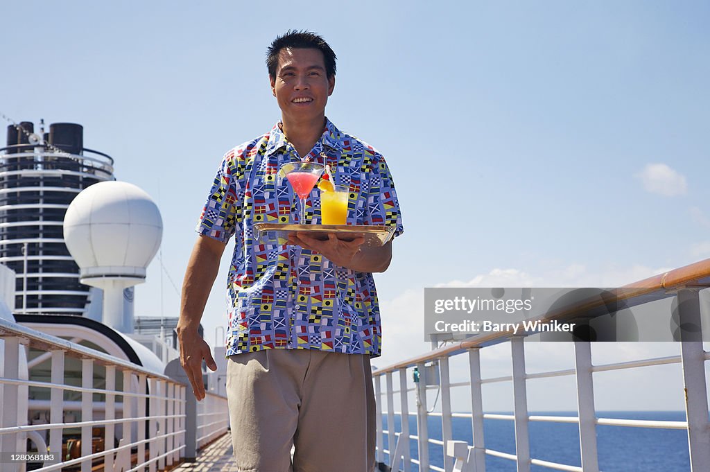 Bartender walking on deck with tray of mixed drinks aboard Holland America Line's Westerdam, February 2010