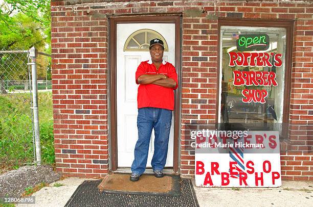 barbershop owner in front of his own barber shop in pensacola, florida, usa - barber shop stockfoto's en -beelden