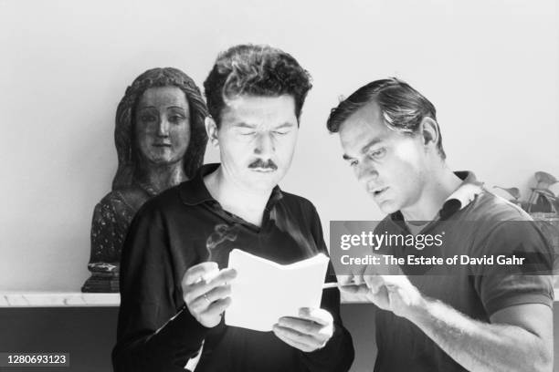French author and filmmaker Alain Robbe-Grillet and Grove Press editor Richard Seaver confer on a manuscript in September, 1964 in New York City, New...