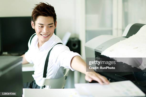 young businessmen working in the office - コンピュータプリンタ ストックフォトと画像