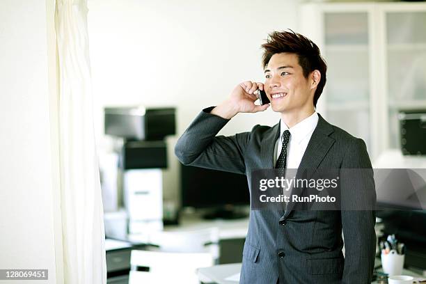 businessmen talking on a mobile in the office - ビジネスフォーマル ストックフォトと画像