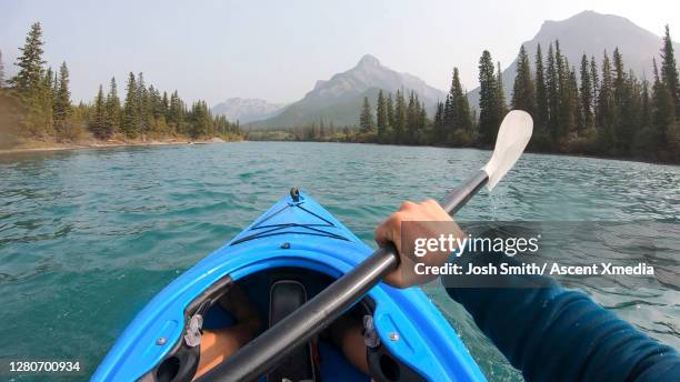 pov past kayakers arms paddling down a mountain river - personal perspective or pov stock pictures, royalty-free photos & images