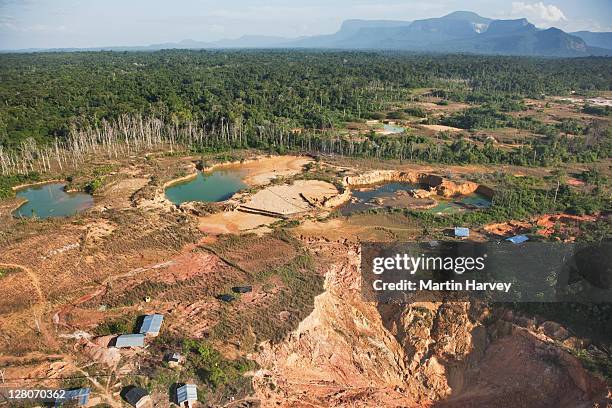 forest destruction caused by mining gold deposits. soil is blasted with powerful jets of water, causing chemical pollution which has a major impact on the rain forest environment, venezuela, south america - ontbossing stockfoto's en -beelden