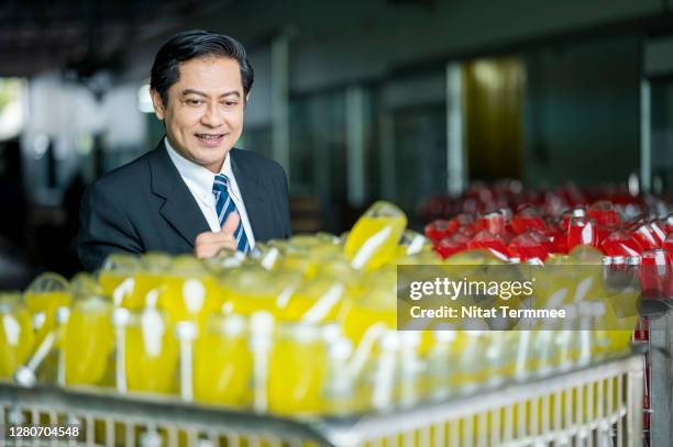 confident of asian businessman in food and beverage industry business while standing in front of the basil seed mixed fruit drink product. - food and drink industry stockfoto's en -beelden