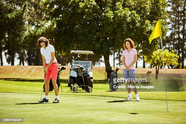 golfer taking shot in golf field during summer - campo golf fotografías e imágenes de stock
