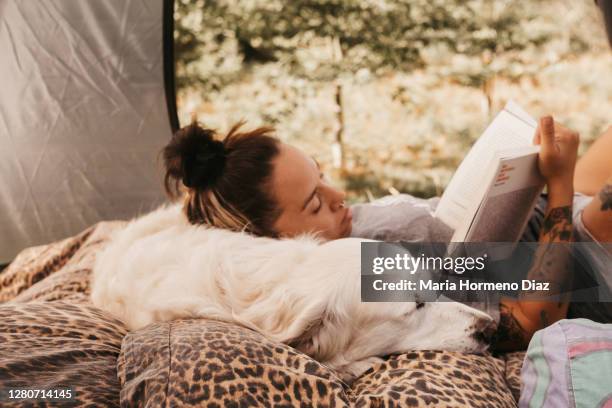 young woman and her dog in a tent in nature - undomesticated cat stock pictures, royalty-free photos & images