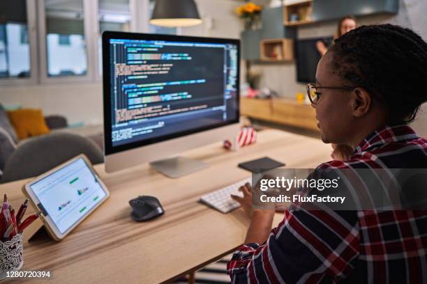 it woman using covid-19 lockdown to finally finish coding for a new software - black woman computer programmer stock pictures, royalty-free photos & images