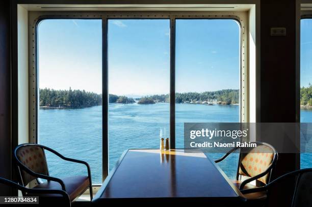 beautiful lush forest-covered islands, viewed from a ferry window on a perfect day - spartan cruiser stock pictures, royalty-free photos & images