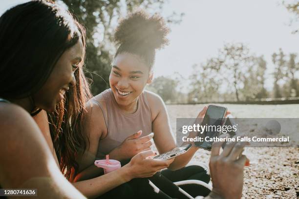 three friends taking a break from exercising outdoors - influencer phone stock pictures, royalty-free photos & images