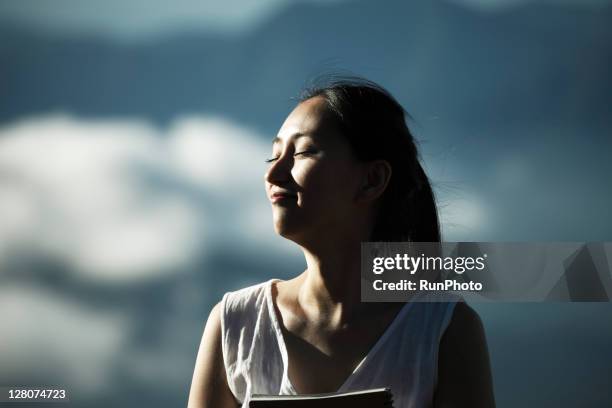 woman feeling the wind at the mountain - japanese ethnicity stock pictures, royalty-free photos & images