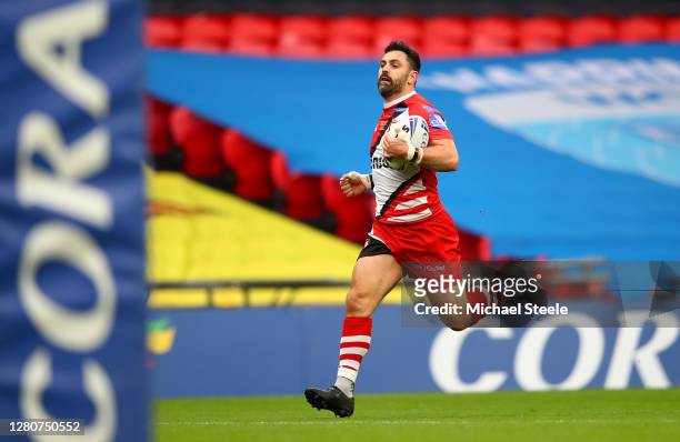 Rhys Williams of Salford Red Devils breaks away to score his team's first try during the Coral Challenge Cup Final match between Leeds Rhinos and...