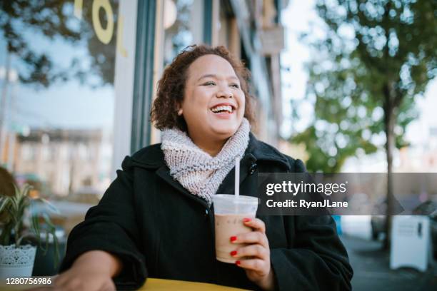 woman working on laptop outside coffee shop - fall in seattle stock pictures, royalty-free photos & images