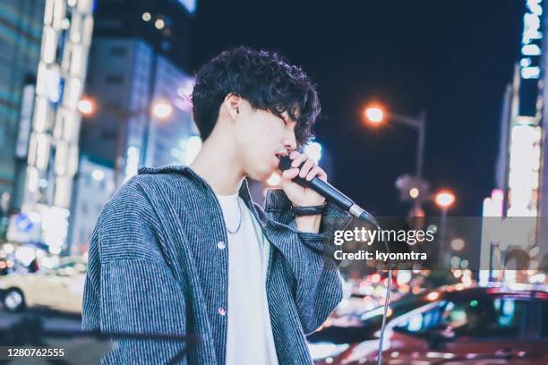 portrait of asian street musician performing on street at night - man singing stock pictures, royalty-free photos & images