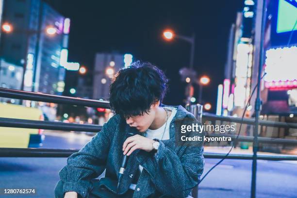 portrait of asian street musician performing on street at night - pop musician stock pictures, royalty-free photos & images