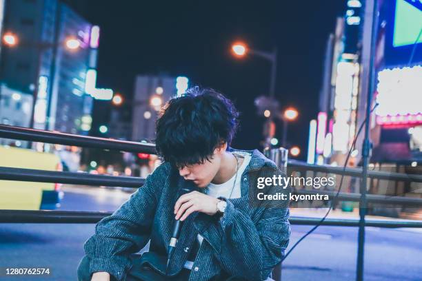 retrato de músico de rua asiático se apresentando na rua à noite - musica pop - fotografias e filmes do acervo