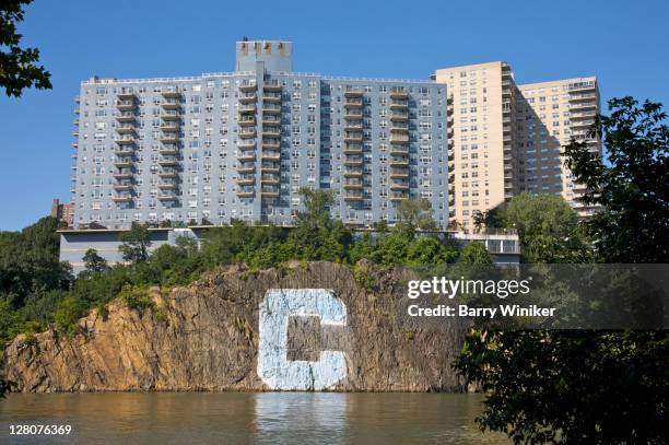 columbia university 'c' painted on boulder near inwood hill park, below apartment buildings, new york, ny - riverdale stock pictures, royalty-free photos & images