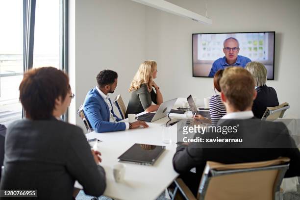 executive team and ceo communicating in video conference - big screen television stock pictures, royalty-free photos & images