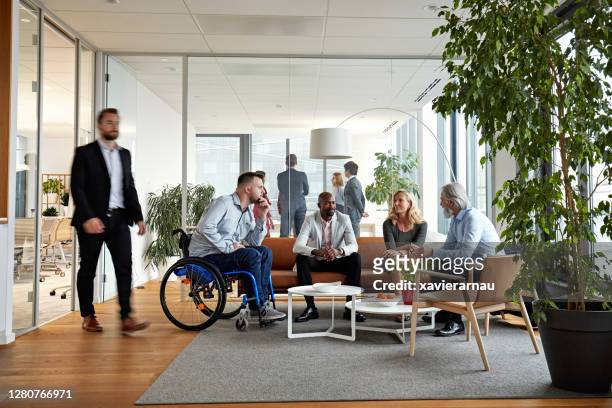 diverse executive team meeting im büroempfangsraum - persons with disabilities stock-fotos und bilder