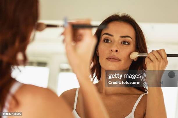 después de su rutina de maquillaje matutino - applying makeup with brush fotografías e imágenes de stock