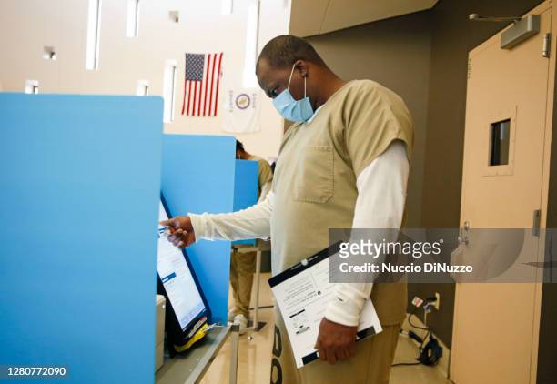 Cook County jail detainee uses a touch screen to cast his votes at a polling in the facility set up for early voting on October 17, 2020 in Chicago,...