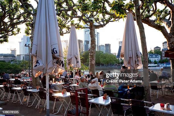 outside cafe and beer garden, by main river, frankfurt, germany - biergarten stockfoto's en -beelden