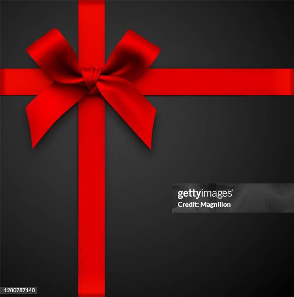 red gift bow with ribbon on a black background - gift ribbon stock illustrations