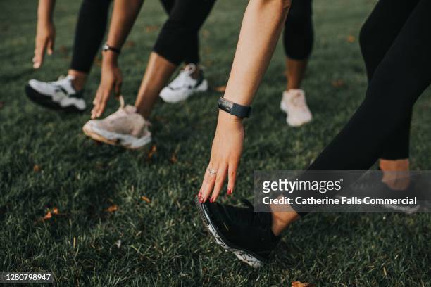 close-up of woman stretching their hamstrings - group exercising stock pictures, royalty-free photos & images