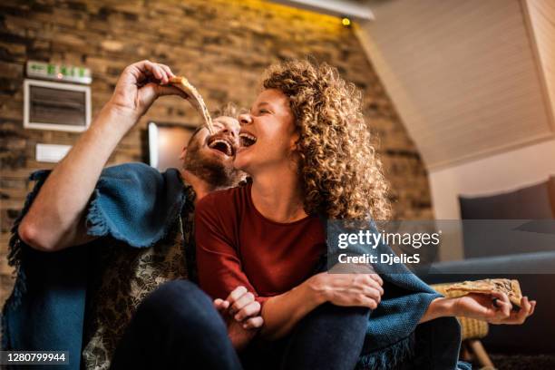 young couple eating pizza. - pizza humour stock pictures, royalty-free photos & images