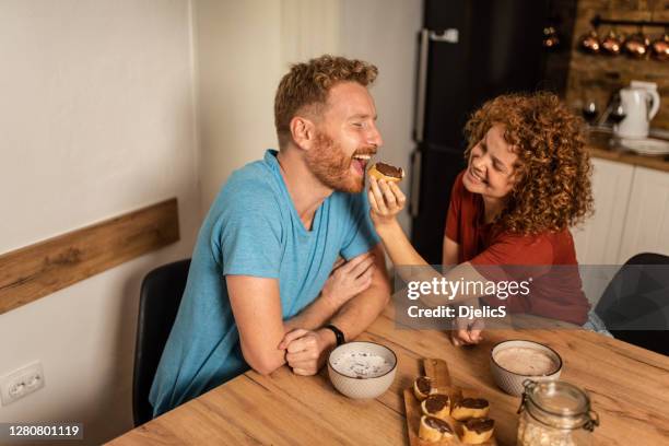 um jovem casal tomando café da manhã juntos. - couple chocolate - fotografias e filmes do acervo