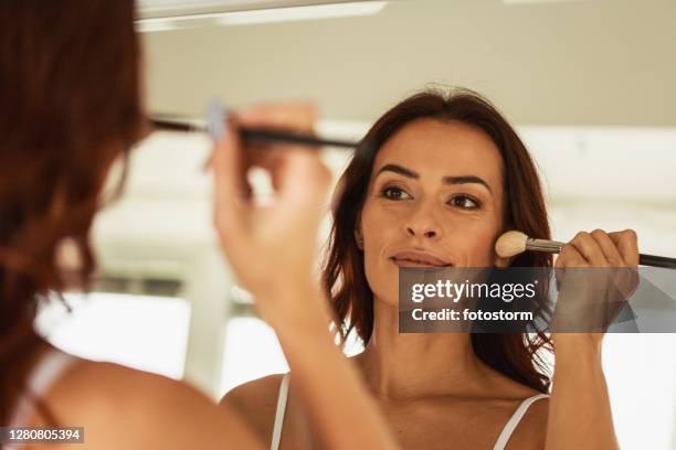 make-up routine of a pretty woman - woman applying blush stock pictures, royalty-free photos & images