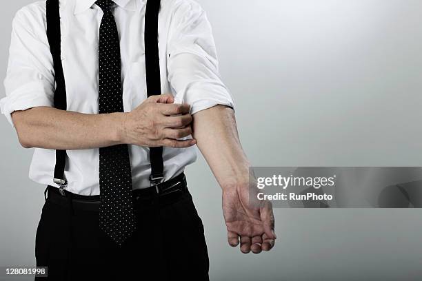 old age businessman turning up cuff on shirt - business man rolled up sleeves stock pictures, royalty-free photos & images