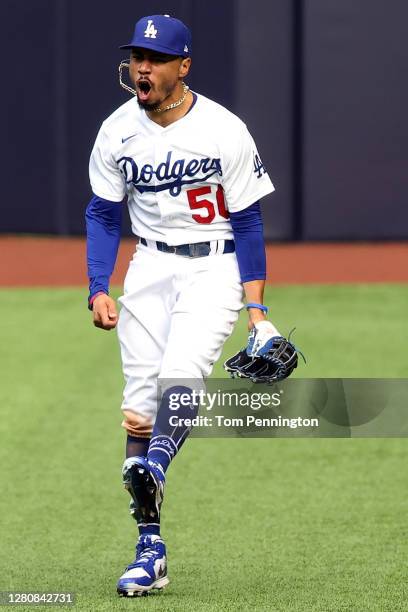 Mookie Betts of the Los Angeles Dodgers celebrates after catching a fly ball at the wall on a hit by Marcell Ozuna , the Atlanta Braves during the...