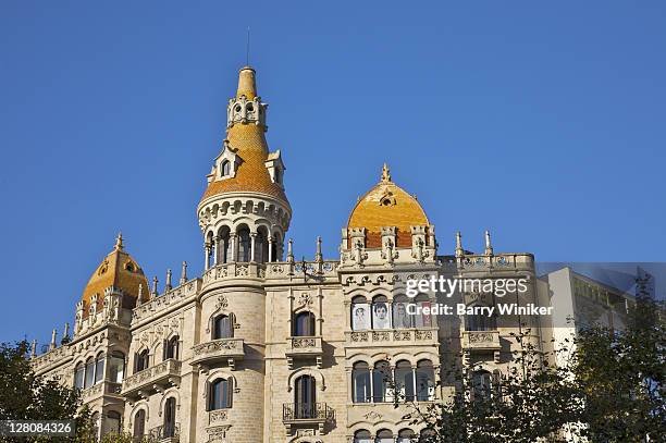 towers atop building on passeig de gracia at placa de catalunya, barcelona, spain - catalonia square stock-fotos und bilder