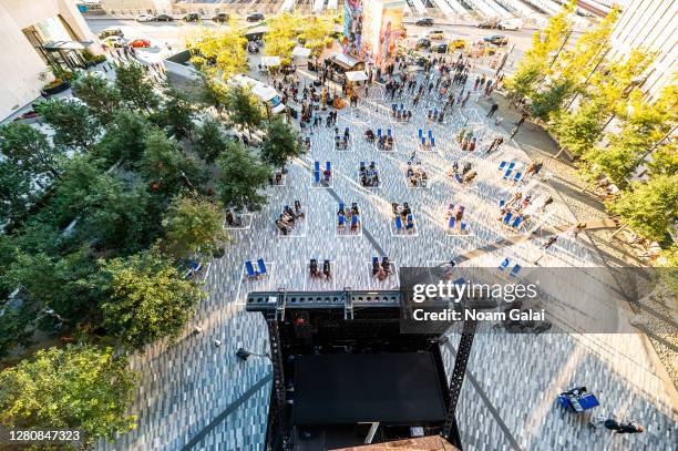 People watch a movie curated by the Tribeca Film Festival in a socially distant pods with cabana-style seating in The Backyard at the Hudson Yards as...