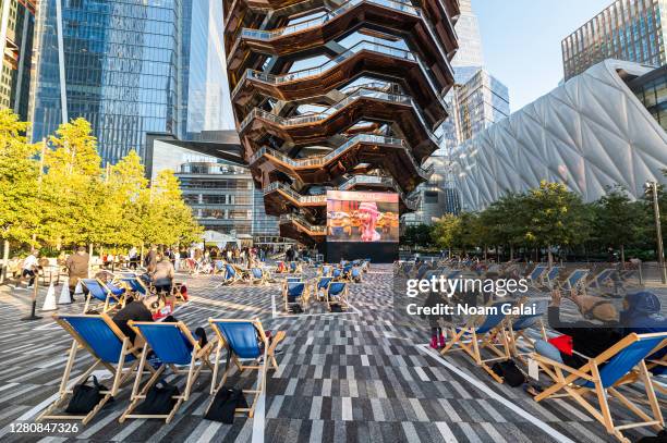 People watch a movie curated by the Tribeca Film Festival in a socially distant pods with cabana-style seating in The Backyard at the Hudson Yards as...