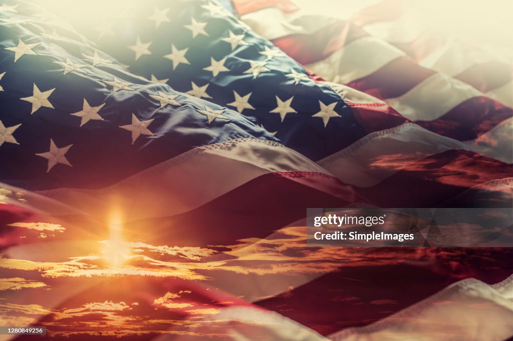American flag waving in the windat sunset - American symbol of 4th of july independence day democracy and patriotism.