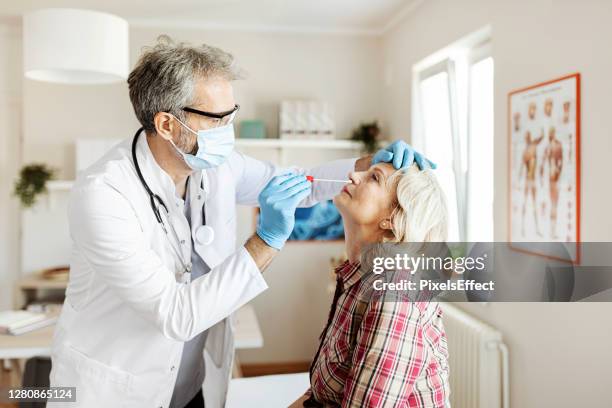 medical worker testing senior woman - serbia covid stock pictures, royalty-free photos & images