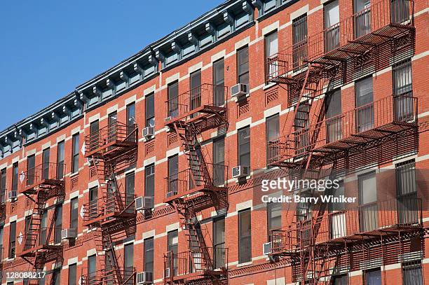 colorful red brick apartments with fire escapes on west 125th street, harlem, new york, usa, march 2010 - harlem new york stock pictures, royalty-free photos & images