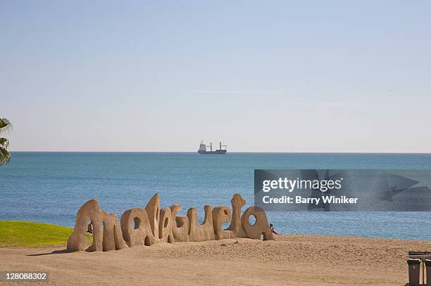 malagueta sign on beach of malaga with boat on the mediterranean sea, costa del sol, andalucia, spain - sand sculpture stock pictures, royalty-free photos & images