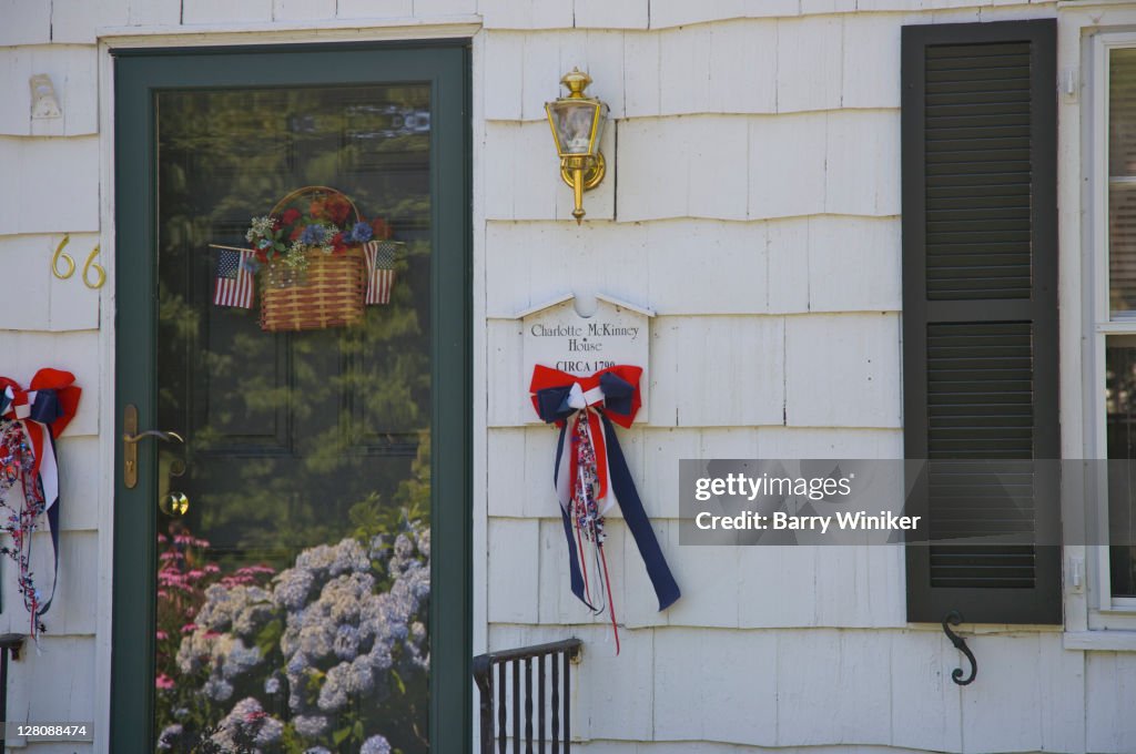 Ribbons, flowers, flag, basket on front of historic house in Stony Brook, NY, U.S.A.