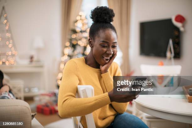 in kontakt mit freunden und familie während der winterferien - african american christmas images stock-fotos und bilder
