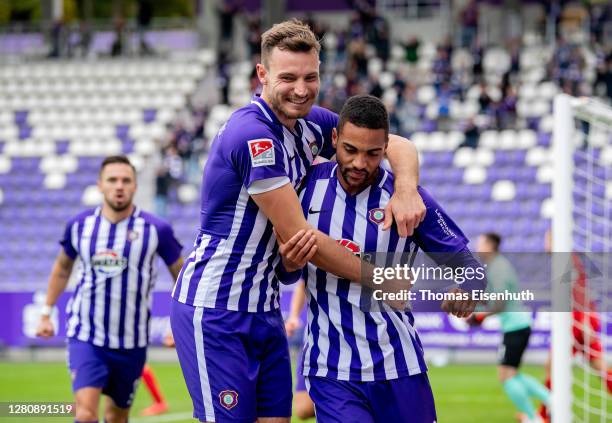 Malcolm Cacutalua of Aue celebrates after scoring his team's first goal with teammate Soeren Gonther during the Second Bundesliga match between FC...