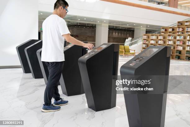 asian young men use mobile phones to pass through the gate - city sensors stock pictures, royalty-free photos & images