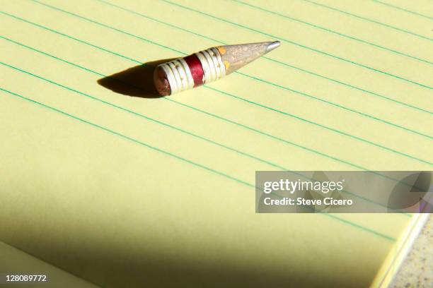 close-up of well used pencil on yellow notepad - yellow pencil stock pictures, royalty-free photos & images