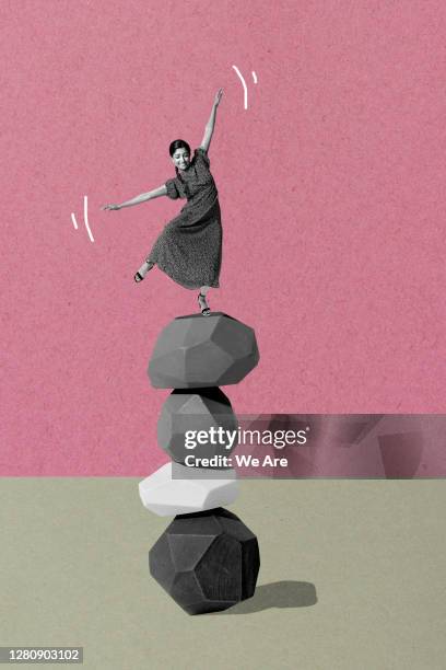 woman balancing on pile of stones - asymmetric dress stock-fotos und bilder