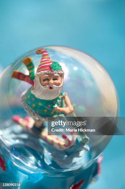 santa claus waterskiiing inside a snowglobe by the side of a pool - funny snow globe stock pictures, royalty-free photos & images