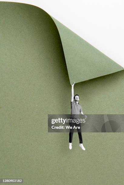 man hanging from cliff - paper craft stock-fotos und bilder