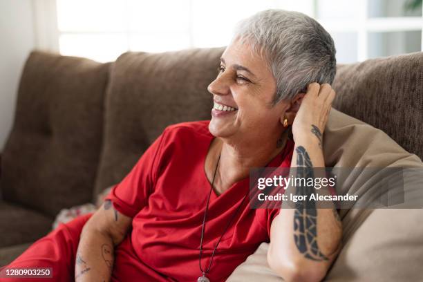 relaxed and happy on the couch - old woman tattoos stock pictures, royalty-free photos & images