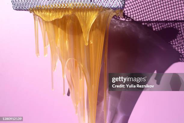 flowing yellow soap on the pink background - slime stock pictures, royalty-free photos & images